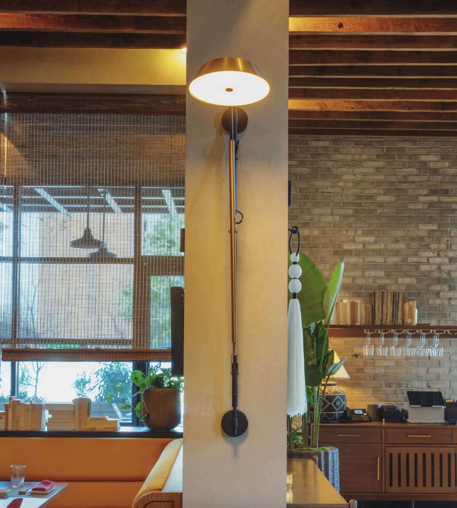 Custom decorative wall sconce by Trinity Lighting installed within a hospitality restaurant environment.
